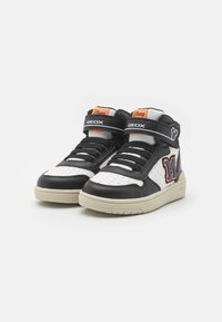 Sneaker alte in bianco e nero con perforazioni a motivo, dettagli arancioni e logo "M" cucito. Presentano cinturini in Velcro e suola in gomma.