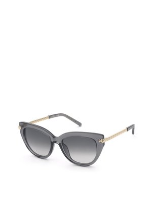 Lunettes de soleil œil de chat noires avec verres dégradés foncés et branches texturées chaîne dorée sur fond blanc.