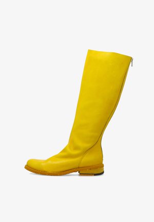 Wysoki żółty skórzany but z niskim drewnianym obcasem i tylnym zamkiem błyskawicznym, widoczny z boku na białym tle.