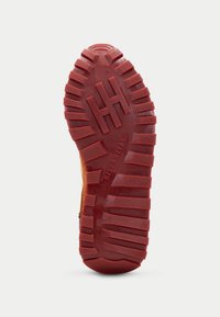 Suola di scarpa in gomma con profonde scanalature, di colore rosso, superficie testurizzata e branding "HISPANITAS". Presenta il logo "H" in rilievo e la taglia "37".