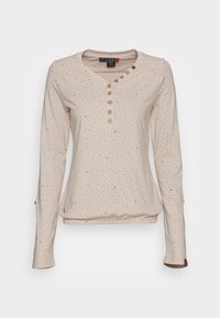 Long-sleeve beige top with small brown dotted pattern, round neckline, five buttons, and slight gathering at the hem. Soft fabric texture.