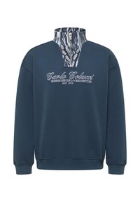 Laivastonsininen collegepaita, jossa neljänneksen vetoketjukaulus. Sisäkauluksessa kuvioitu kangas ja keskellä logoteksti. Pehmeä kangas, jossa resorit hihansuissa ja helmassa.