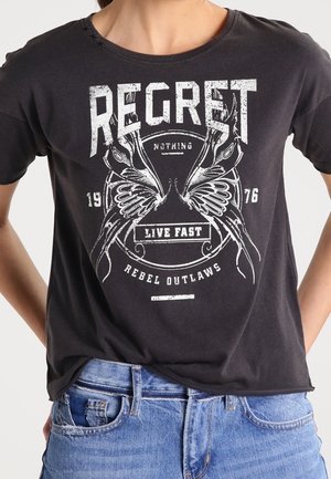 T-shirt in cotone nero con grafica serigrafata che include testo ed elementi decorativi, tra cui ali e armi da fuoco, in bianco.