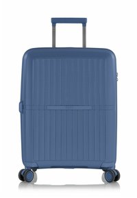 Valigia rigida blu con texture a righe verticali, manico retraibile, quattro ruote e un compartimento con zip. Presenta il marchio HEYS.