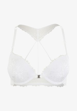 Soutien-gorge en dentelle blanche avec des motifs floraux delineés, des bords festonnés et un design de bretelles en V au dos. Il est doté d'une fermeture centrale en métal.