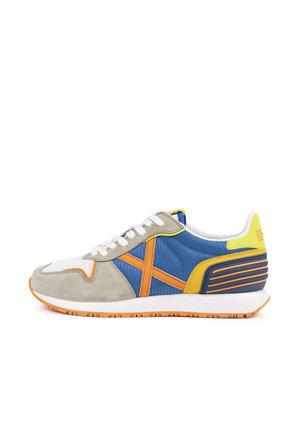 Zapatillas que combinan varios materiales: ante gris, pana azul y malla blanca. Detalles en naranja y amarillo. Suela de goma texturizada.