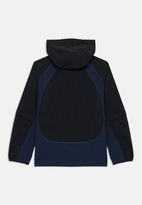 Veste à capuche en bleu marine foncé avec un panneau arrière texturé. Dispose d'accents de manches contrastants et de poignets élastiques. Fabriquée en matériau extensible.