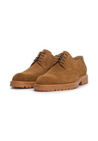 Zapatos de gamuza marrón con cordones, con detalles de brogue, puntera redondeada y suela de goma; cuentan con cordones marrones y acentos en tono claro.