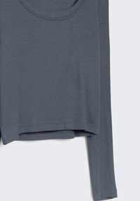 Haut à manches longues en maille côtelée de couleur bleu-gris atténuée, avec un col rond et une coupe courte. Tissu doux et texturé.