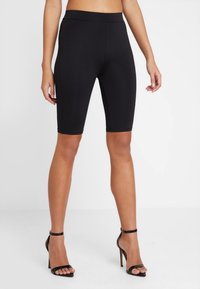 Svarta cykelshorts i knälängd tillverkade av stretchy tyg med en mjuk textur, med en bred midja för komfort och stöd.