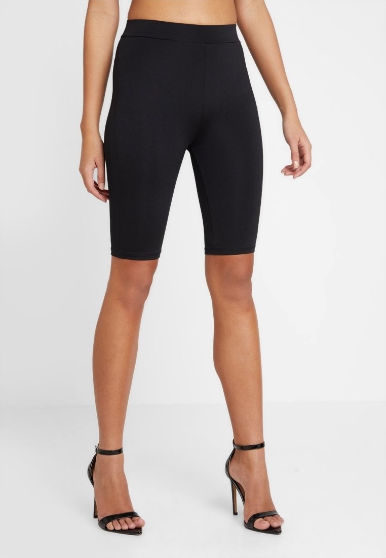 Svarta cykelshorts i knälängd tillverkade av stretchy tyg med en mjuk textur, med en bred midja för komfort och stöd.