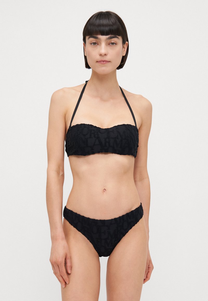 Black bikini set featuring a bandeau top and ruched bikini bottoms, made from textured fabric with subtle logo detailing.