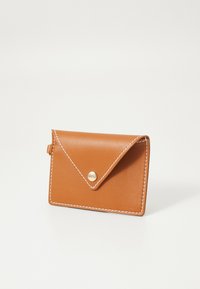 Portafoglio in pelle marrone con chiusura a patta, caratterizzato da cuciture bianche e un bottone a pressione dorato. Forma compatta e rettangolare con una texture liscia.