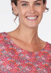 Rotes Oberteil mit floralem Muster und kurzen Ärmeln; zeigt kleine blaue und orangefarbene Blumen auf einem strukturierten Stoff. Rundhalsausschnitt.