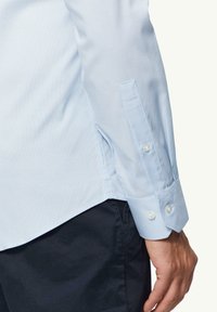 Lichtblauw geruit overhemddas met een button-down kraag, lange mouwen en witte knopen op de manchetten. Getailleerde pasvorm met een gebogen zoom.