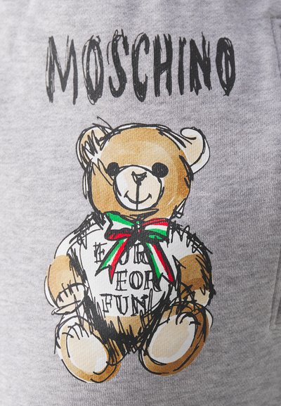 Szürke pamut pulóver, amelyen egy rajzolt mackó minta található színes szalaggal és a "FOR FUN" felirattal. A márkaneve "MOSCHINO" a minta felett.