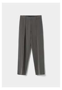 Grå skräddarsydda byxor med frontveck, sidofickor, midja med bälteshällor och ankellås, uppvisade på en vit bakgrund.