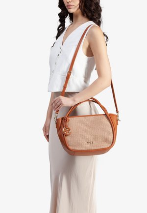 Borsa in pelle marrone con texture intrecciata sul davanti, un charm circolare e tracolla regolabile. Presenta dettagli in metallo dorato e il logo del marchio.