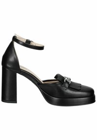 Chaussure à talon haut en cuir noir avec bride à la cheville, talon épais, semelle plateforme et franges décoratives avec boucle métallique à l'avant.