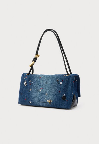 Borsa in denim con chiusura a patta, manico in pelle nera, decorata con applicazioni colorate e accenti metallici, caratterizzata da un design a fiocco.