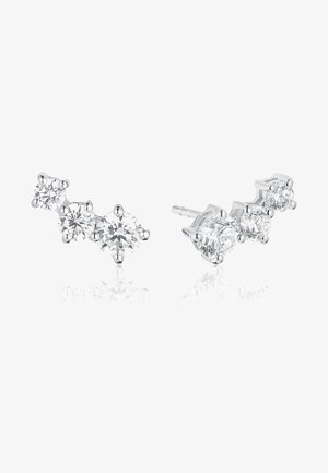 Boucles d'oreilles en argent avec trois pierres précieuses rondes transparentes chacune, disposées en ligne courbe, présentées sur fond blanc.