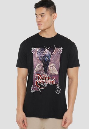 Black cotton t-shirt featuring a graphic design from "The Dark Crystal" with a central crystal and character illustrations in vibrant colors.