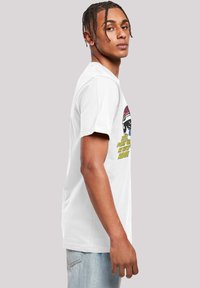 White cotton t-shirt featuring a front graphic of a racing helmet with colorful text saying "Just picked up my new ride!" in bold yellow.