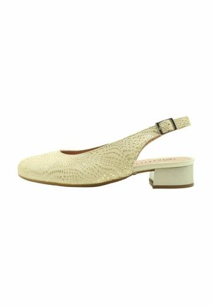 Zapato slingback beige con punta redondeada, parte superior texturizada con un patrón de olas en relieve y un tacón bajo cuadrado. Cierre con hebilla en la correa.