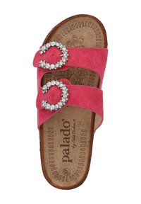 Pink suede slide sandal with two circular rhinestone buckles. Featuring a cork insole with floral design and textured outsole.