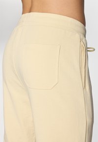 Lysegule sweatpants med en enkelt baglomme og et elastisk talje med snøre, fremstillet af blødt bomuldsstof.