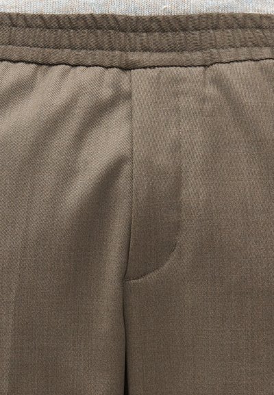 Καφέ ραμμένο παντελόνι από υφασμάτινη υφή, με επίπεδη μπροστινή όψη και δύο τσέπες, καθώς και ελαστική μέση για άνεση.