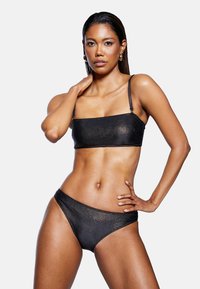 Czarny, żebrowany zestaw bikini z prostokątnym topem crop z cienkimi ramiączkami oraz dopasowanymi, wysokimi majtkami. Gładka tekstura, minimalistyczny design.