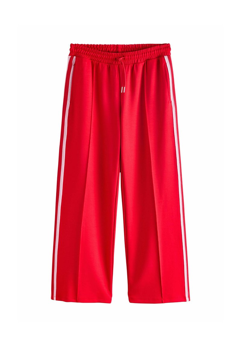 Pantaloni atletici roșii cu un croi larg, având un elastic la talie și dungi albe pe laterale. Realizați dintr-un material fin și ușor.