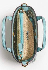Cutout skuldertaske med lyseblåt kunstlæder ydre. Indeholder en indvendig pose af strå-lignende materiale med en blå lynlås og guldfarvede detaljer.