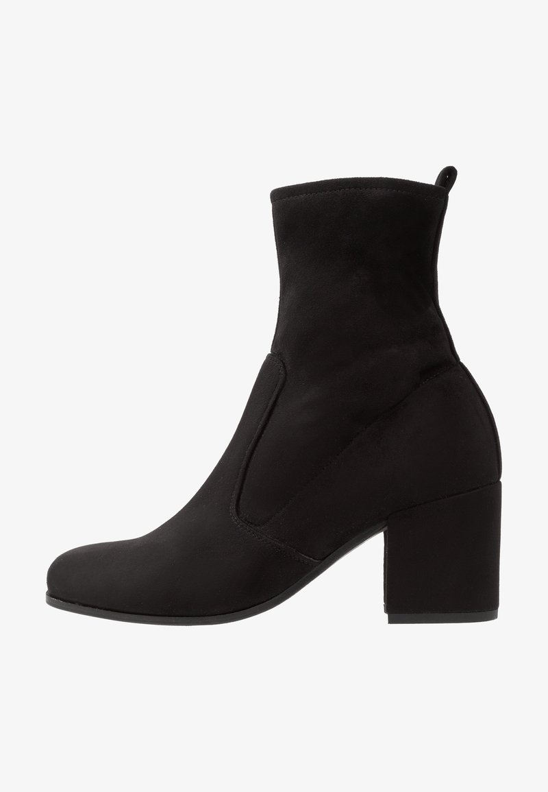 Botte femme mi-mollet en daim noir avec bout arrondi, talon bloc et languette à l’arrière.