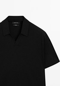 Černé bavlněné polo tričko s designem do V, krátkými rukávy a hladkou texturou. Obsahuje decentní značkovou etiketu uvnitř límce.