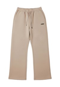 Pantalones deportivos beige hechos de tela suave, con cintura de cordón, bolsillos laterales y un pequeño logo oscuro cerca de la cadera izquierda.