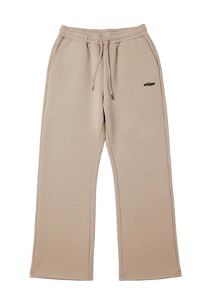Pantalones deportivos beige hechos de tela suave, con cintura de cordón, bolsillos laterales y un pequeño logo oscuro cerca de la cadera izquierda.
