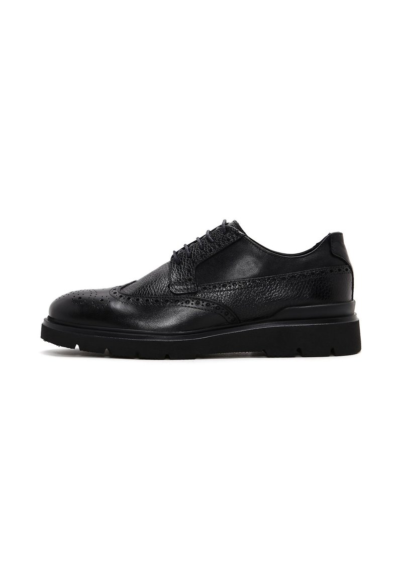 Scarpa da uomo in pelle nera con pannelli testurizzati, design con lacci, dettagli brogue sulla punta e suola spessa in gomma.