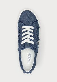 Denim kedas ar saplais malu detaļu, baltām auklām un mīkstu zoli. Iekšpusē ir redzams zīmola nosaukums zilā krāsā.