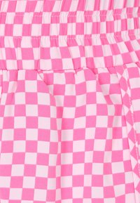 Tessuto a scacchi rosa e bianco con cintura elastica arricciata, caratterizzato da una texture leggera e morbida e da delicate pieghe.