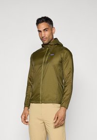 Olive green lightweight jacket with a hood, zippered front, and long sleeves. Features a small logo on the chest and a smooth, shiny texture.