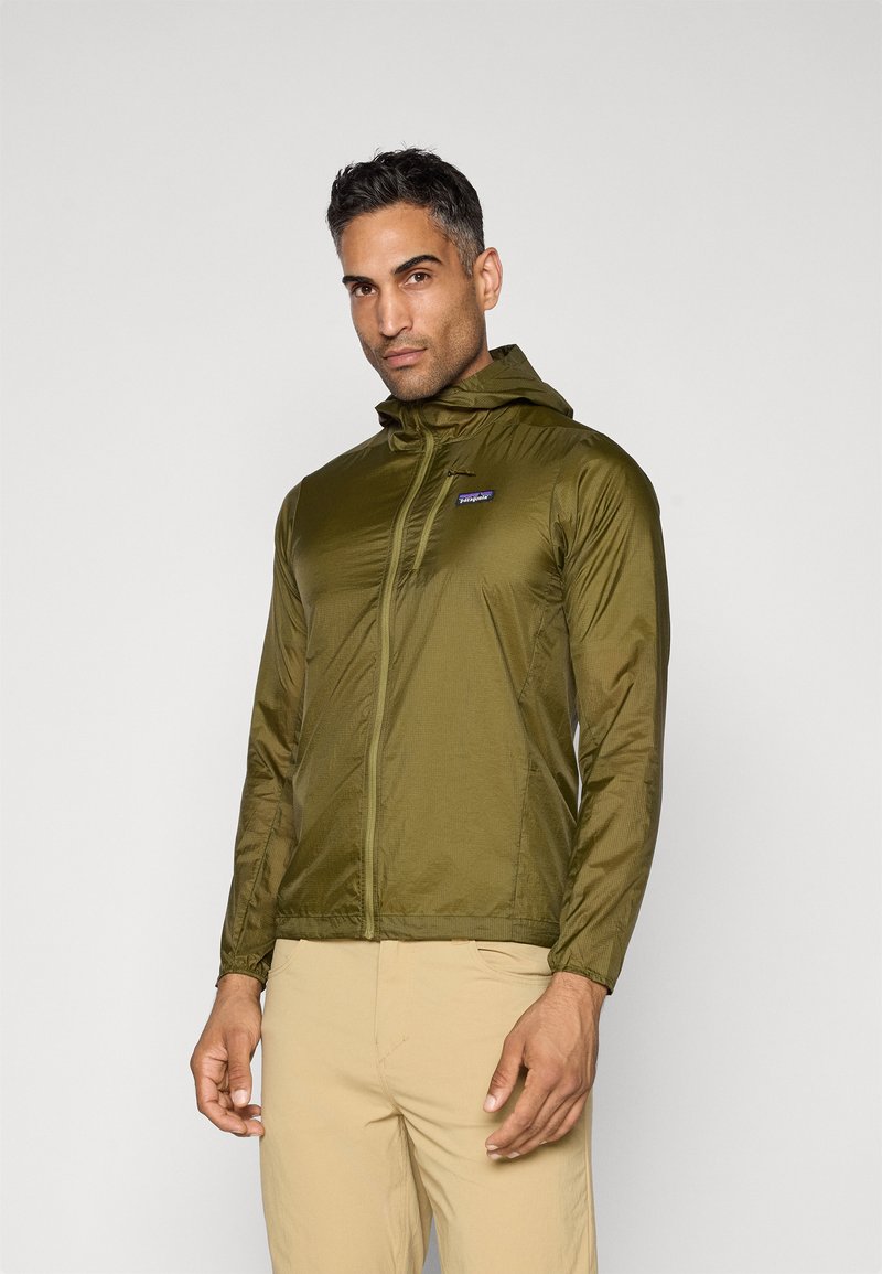 Olive green lightweight jacket with a hood, zippered front, and long sleeves. Features a small logo on the chest and a smooth, shiny texture.