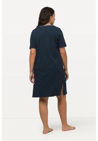 Námornícky modré šaty s krátkym rukávom a bielymi bodkami, s okrúhlym výstrihom a bočnými rozparkami, vyrobené z jemnej látky.