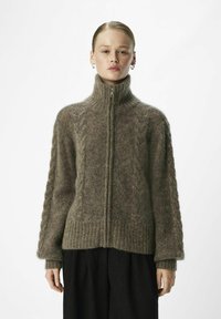 Jersey de lana marrón con cremallera y alto cuello, textura de punto trenzado en los hombros, puños y dobladillo acanalados, diseñado para un ajuste relajado.