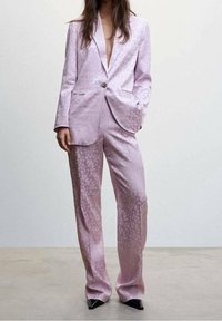 Lilac satin suit featuring a patterned texture, single button closure, and wide-leg trousers. Complete with pointed black heels.