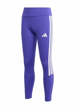 Paarse sportlegging met wit Adidas-logo op de dij en drie witte strepen langs de buitenzijden van de benen.
