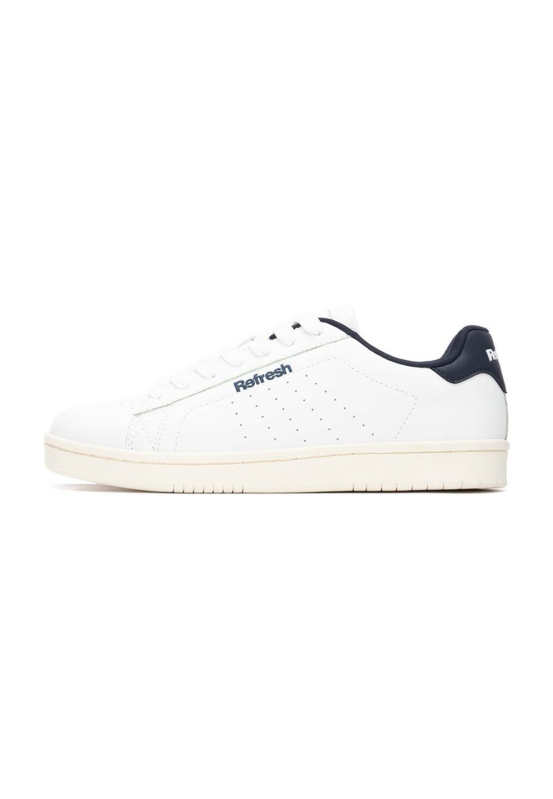 Zapatillas de cuero blanco con diseño de caña baja, acento en el talón azul marino, detalles perforados y suela de goma texturizada. Marca en el lateral.