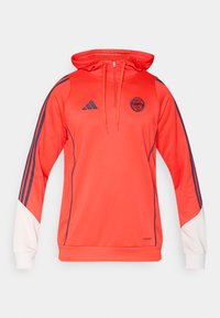 Sweat à capuche rouge Adidas avec une fermeture éclair moitié, capuche avec cordon de serrage et accents bleu marine. Comprend le logo du FC Bayern Munich et des détails blancs sur les manches.