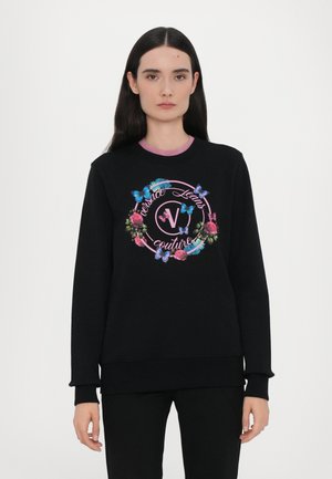Felpa nera con grafica floreale e farfalla. Caratterizzata da un collo tondo e polsini a coste. Accentuata da elementi rosa e blu.